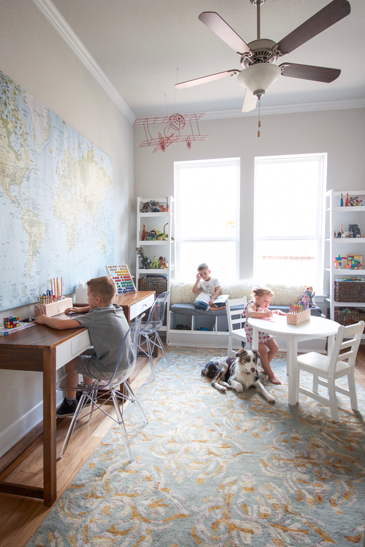 Playroom converted into a multifunctional study space with work areas, shelves, and craft supplies.
