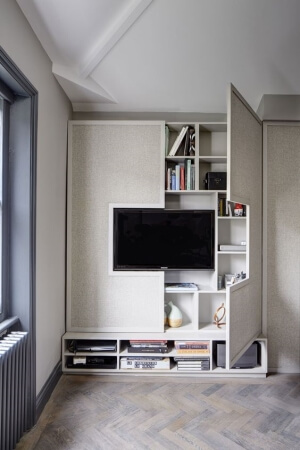 Cabinet doors that open to reveal an entertainment center within the wall