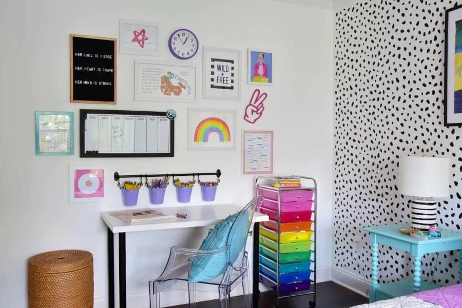 Colorful kids’ homework station with wall art, rainbow storage drawers, and a white desk organized with supplies.