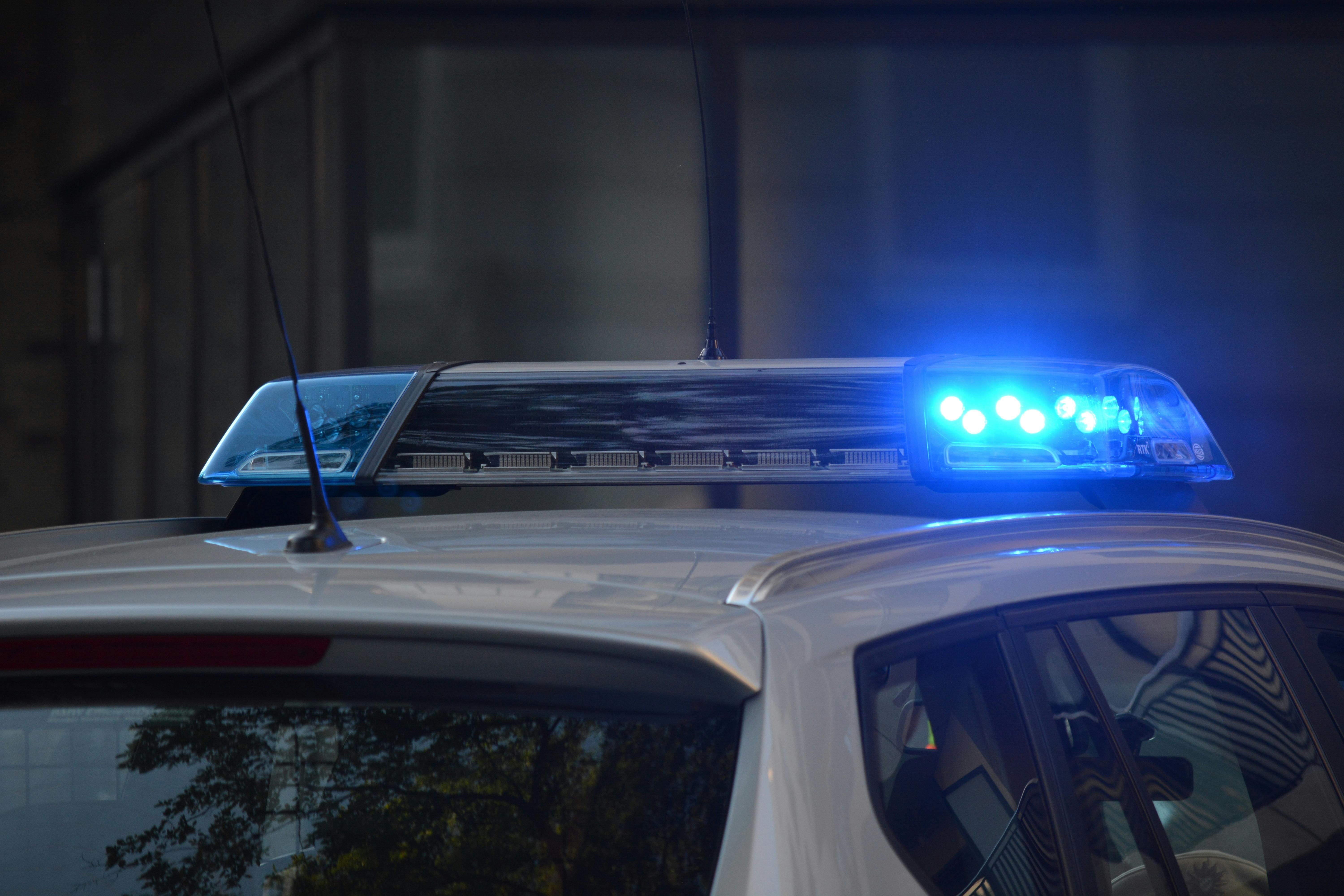 Picture of the roof of a police vehicle from the outside, with the siren lights turned on