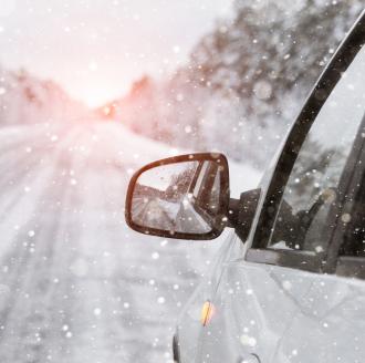 car-driving-down-road-in-snow