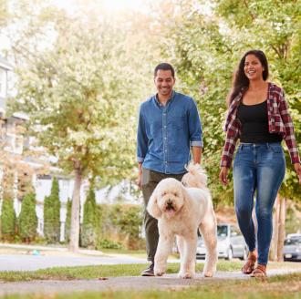 couple-walking-dog-around-neighborhood
