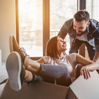 young-man-pushing-young-woman-in-cardboard-box