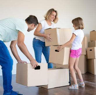 young family packing boxes to move to new home