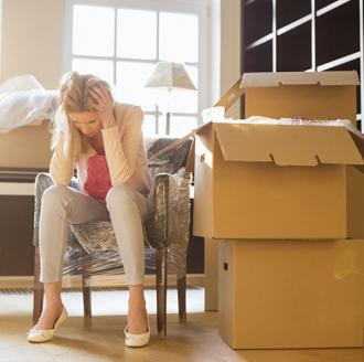 anxious woman sitting next to moving boxes