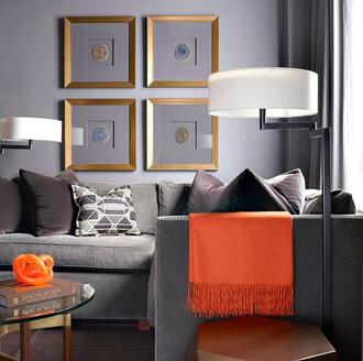 gray themed living room with orange pop of color for accent