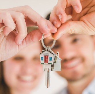 man and woman homeowners with key to new home