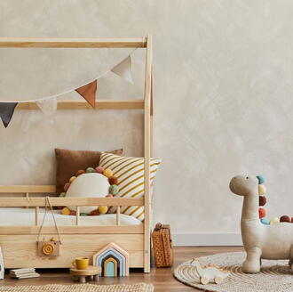 Low-to-the-ground Montessori-style toddler bed with safety rails and cozy bedding for smooth transition.