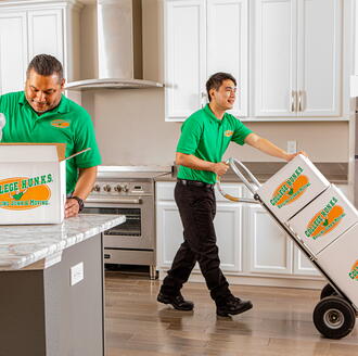 Professional full-service movers carrying boxes into a new home during a stress-free move
