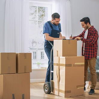 A moving professional explaining hourly vs flat-fee pricing to a customer at a kitchen table.