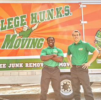 Two College Hunks movers posing in front of a moving truck.