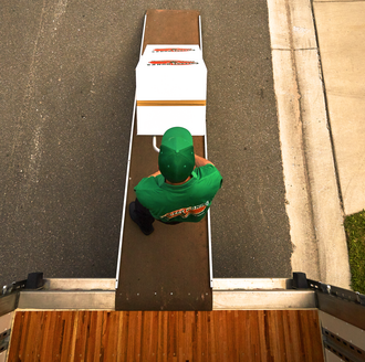 College Hunks mover carrying a box out of a moving truck