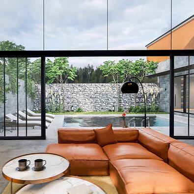Orange couch in living room. Doors opening to outdoor living space. An indoor outdoor living space is shown.