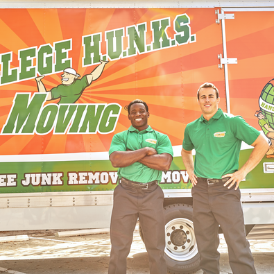 Two College Hunks movers posing in front of a moving truck.