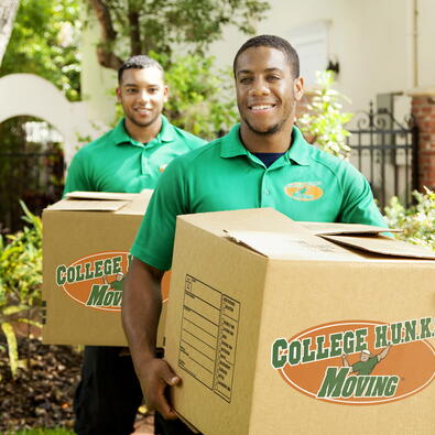 Two College Hunks employees with moving boxes.