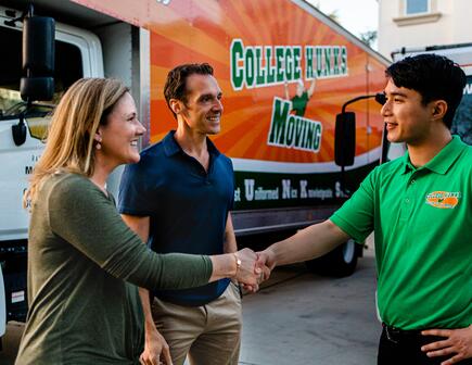 Moving truck, couple meeting with moving company
