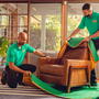 Two College Hunks employees wrapping a couch