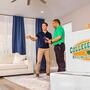 College Hunks employee with a client in a living room